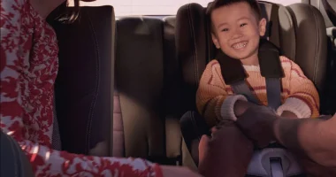 Parent buckling an infant into a car seat in an EQ vehicle