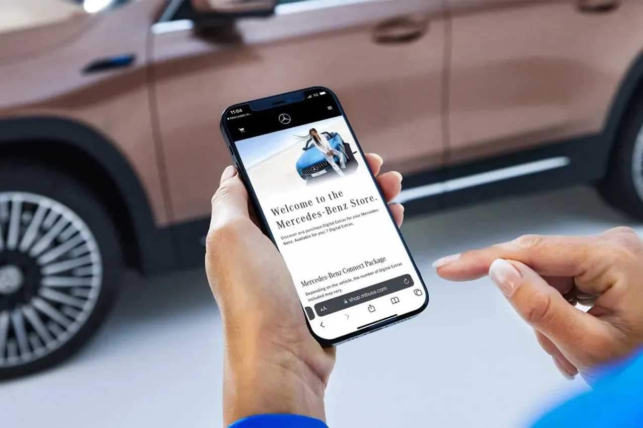 Hand holding a smartphone pairing a vehicle in the Mercedes-Benz app