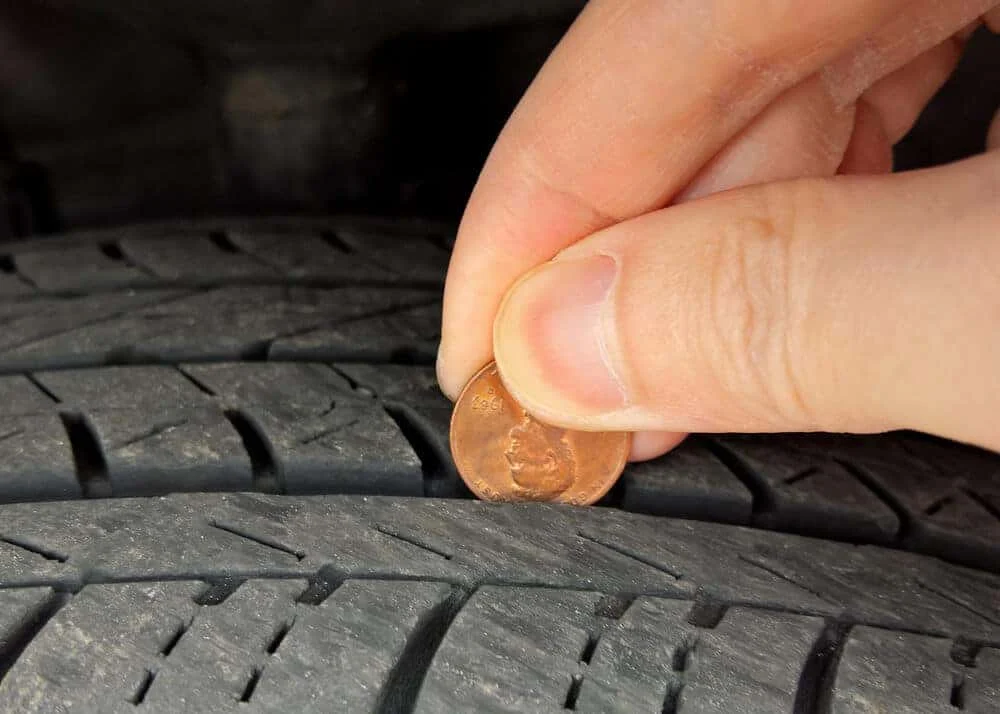 Penny test being performed on a car tire