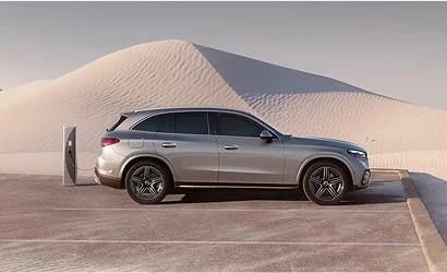 Mercedes-Benz vehicle charging in front of a sand dune
